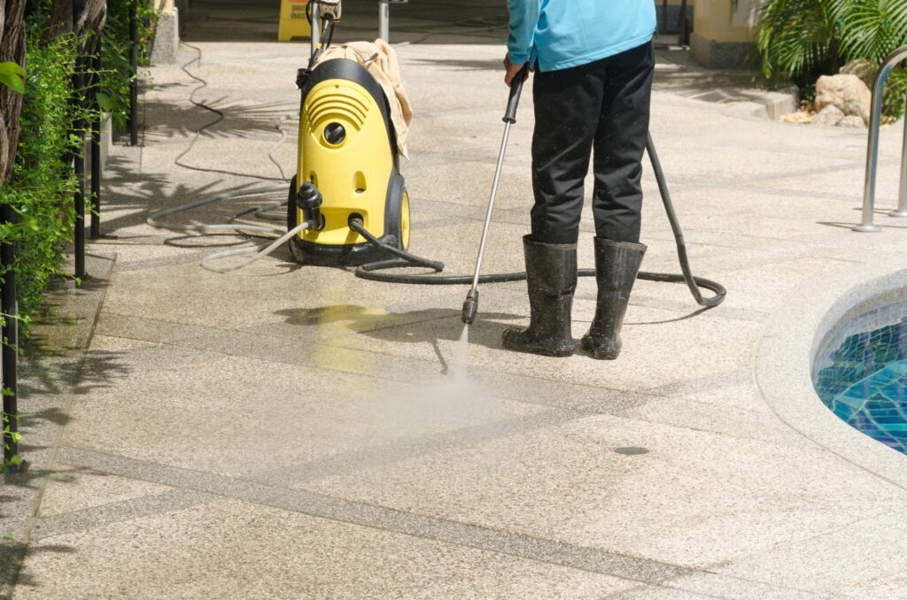 a woman using a pressure washer to clean a pool